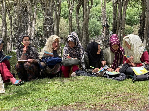 Within the IFERB project, girls sit together as they read and write.