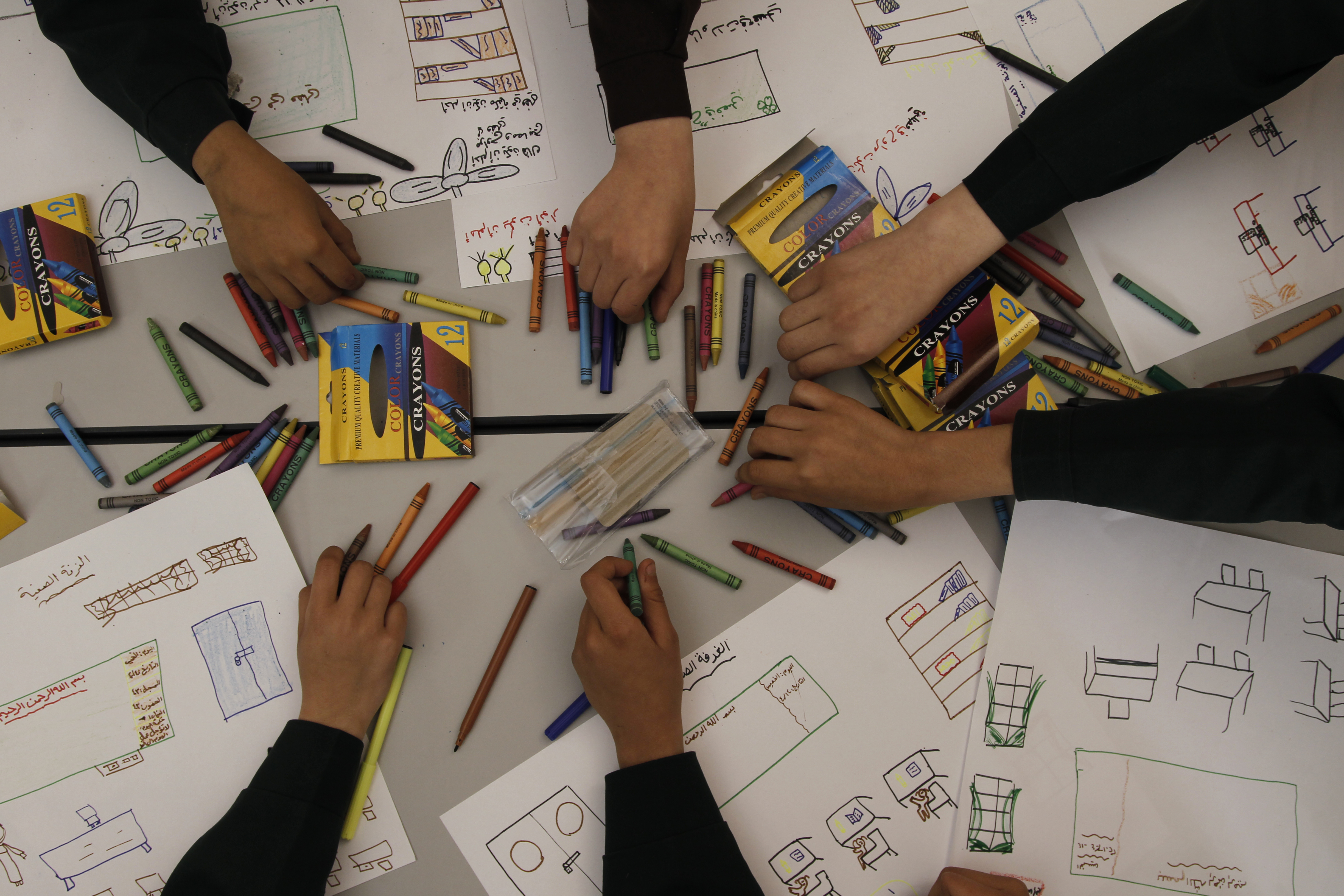 Students writing in crayon. Photo Credit: Eyad El Baba