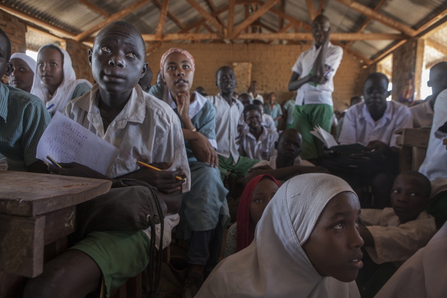 A large group of students sit in a classroom.